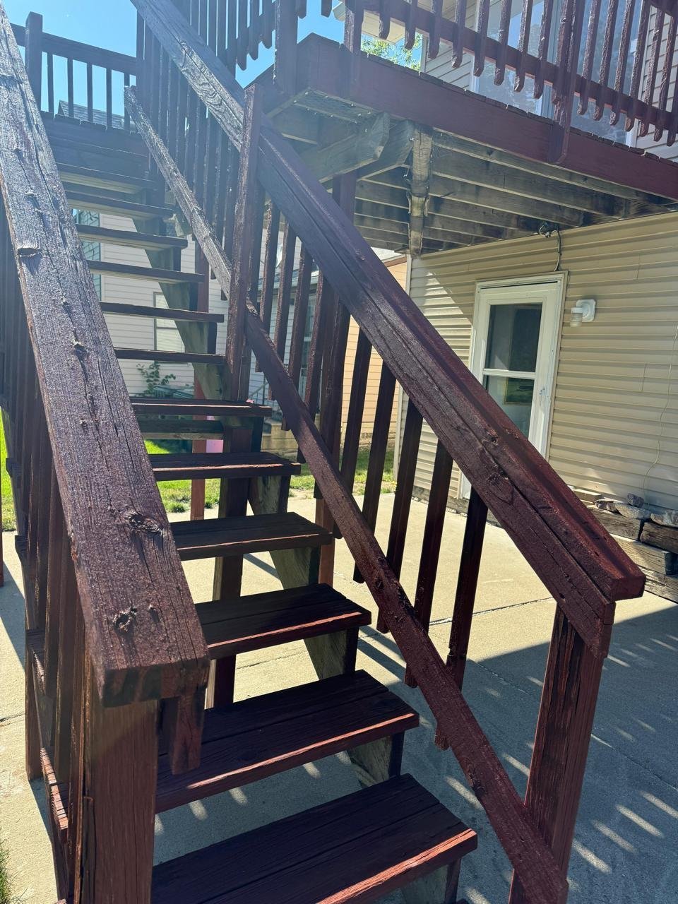 Deck staining on an exterior wooden staircase in Sioux City, IA by Painting Pros